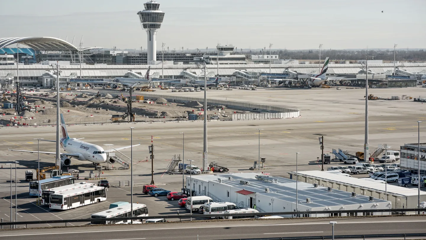 Blick über das Vorfeld des Flughafens München mit Tower und Terminal, davor die Containeranlage der Interimskantine.